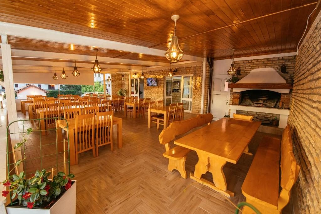 Unutarnja blagovaonica restorana s kamenim kaminom i drvenim stolovima