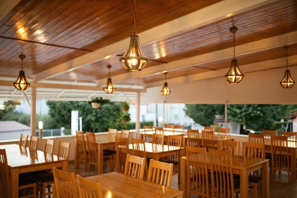 Natkrivena terasa restorana s drvenim stropom i visećim svjetiljkama