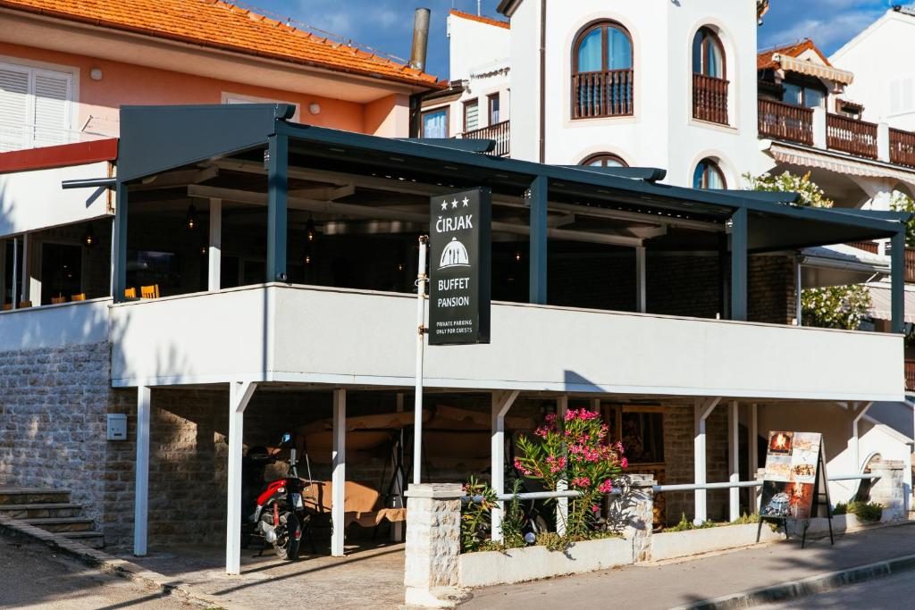 Pročelje pansiona Čirjak s natkrivenom terasom i kamenom oblogom